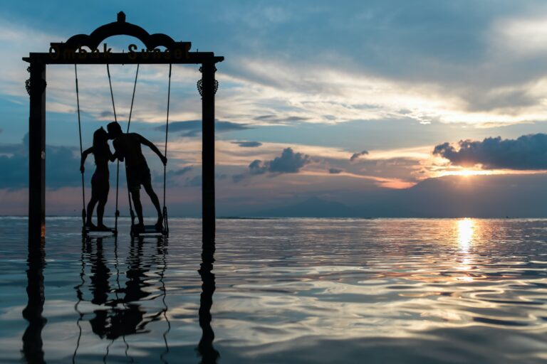 silhouette of couple kissing while standing on water